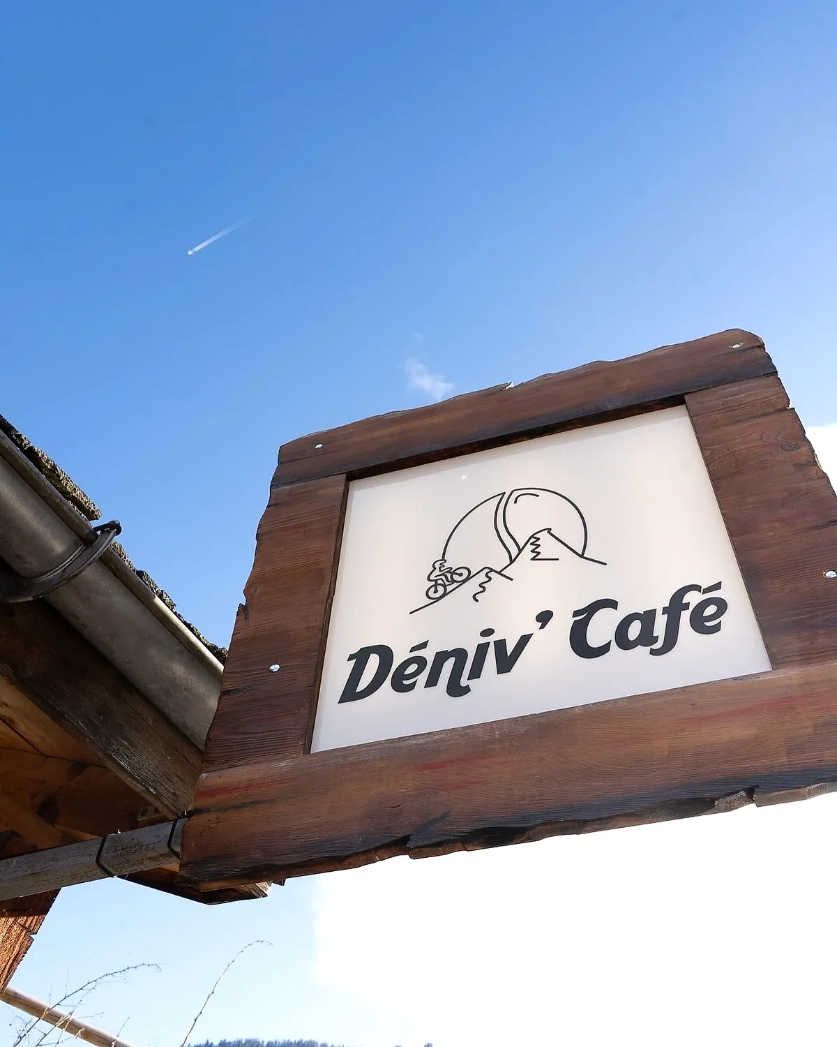 L’enseigne du Déniv’Café sous le ciel bleu